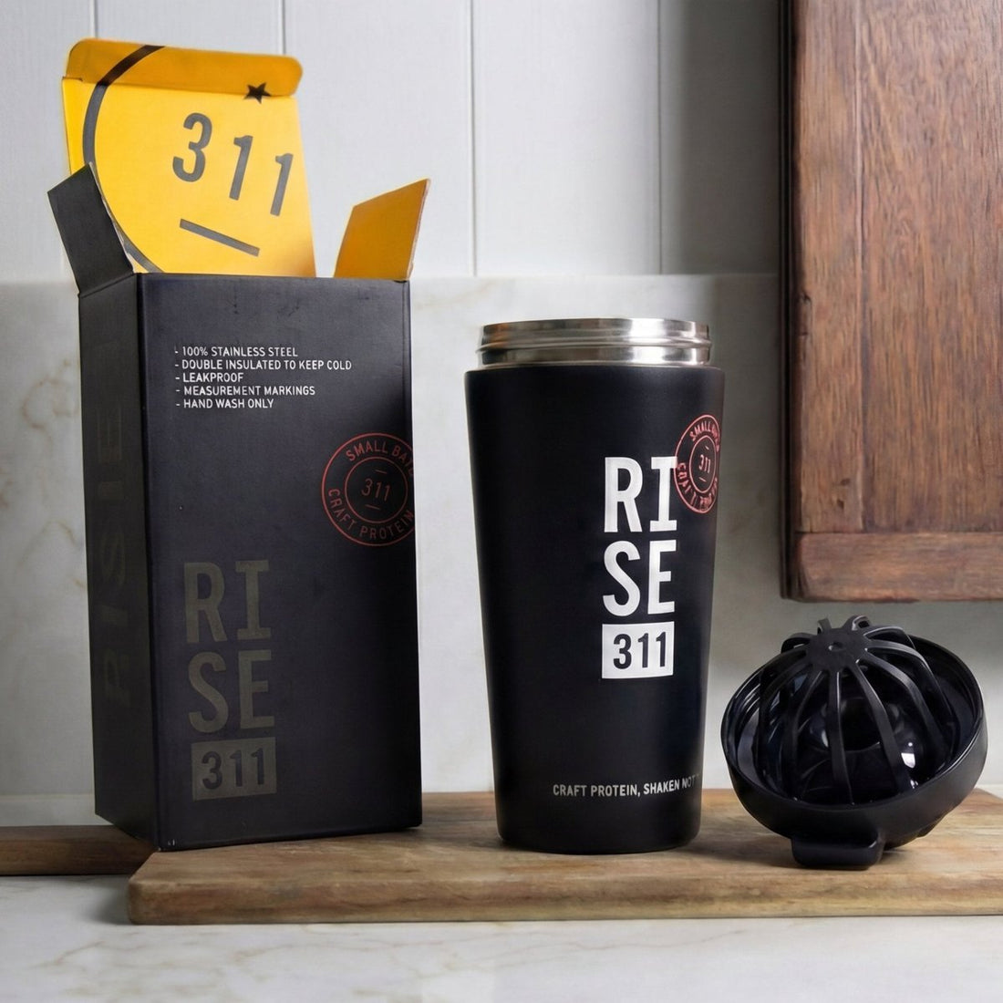RISE311 shaker in box with yellow inside, shaker and blender ball in a wood and marble kitchen